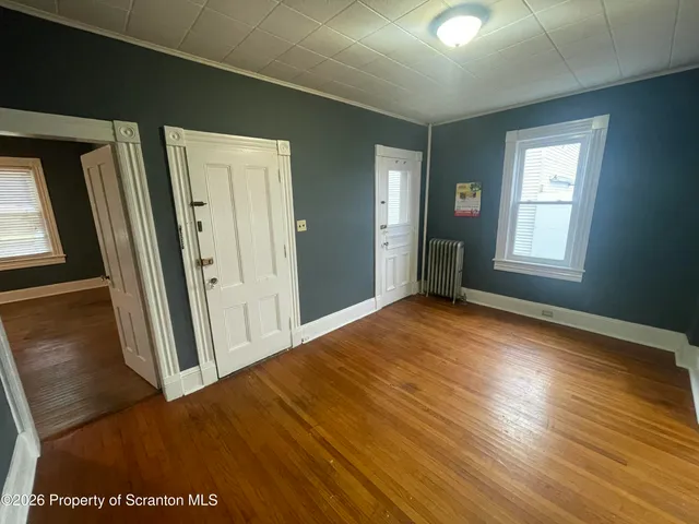 a view of a room with wooden floor and windows
