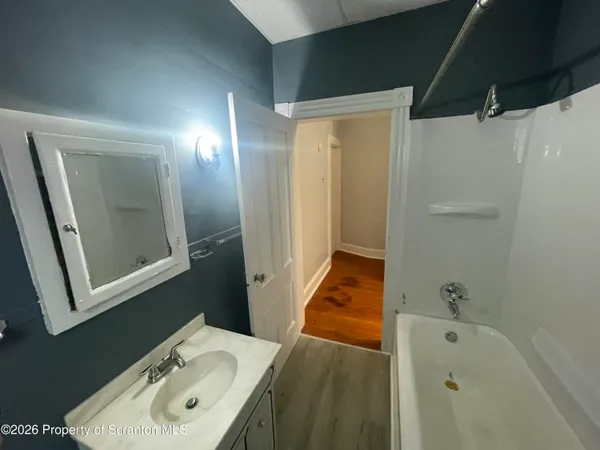 a bathroom with a tub sink and mirror