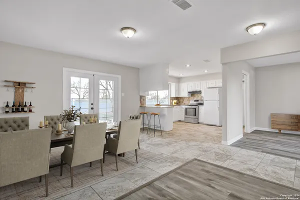 a living room with furniture and a dining table with kitchen view