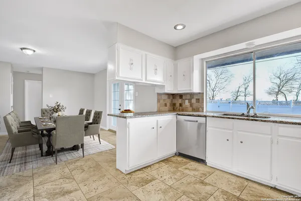 a kitchen with granite countertop cabinets and chairs