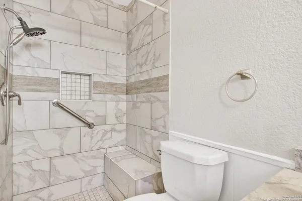 a bathroom with a toilet and a shower