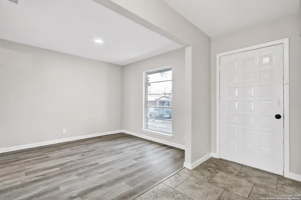 an empty room with wooden floor and window