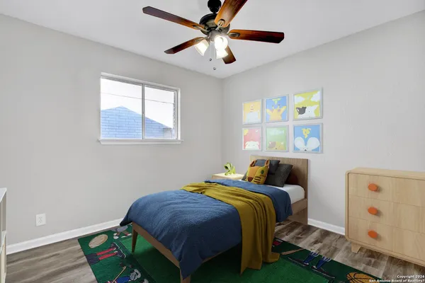 a bedroom with a bed and a chandelier fan