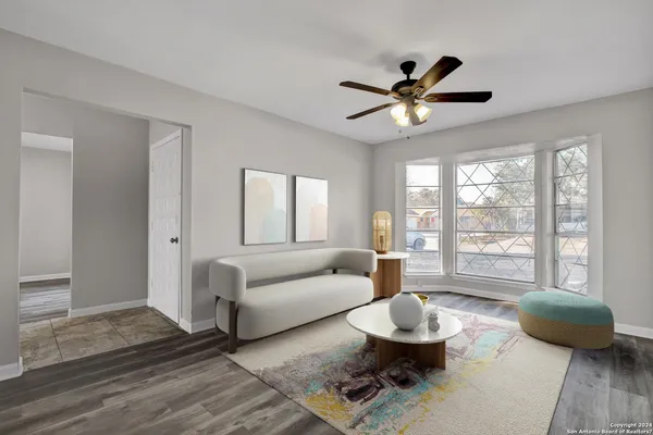 a living room with furniture a window and a ceiling fan
