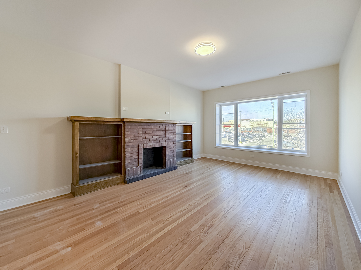 6411 West Irving Park Road, Unit 2 Chicago, IL 60634 - Photo 12 of 21 an empty room with wooden floor fireplace and windows