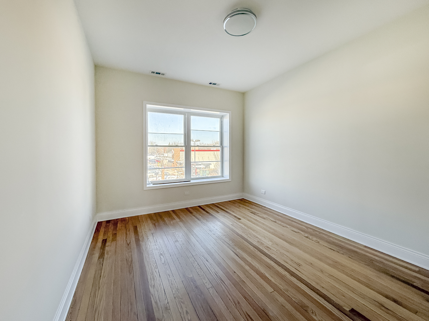 6411 West Irving Park Road, Unit 2 Chicago, IL 60634 - Photo 13 of 21 an empty room with wooden floor and windows