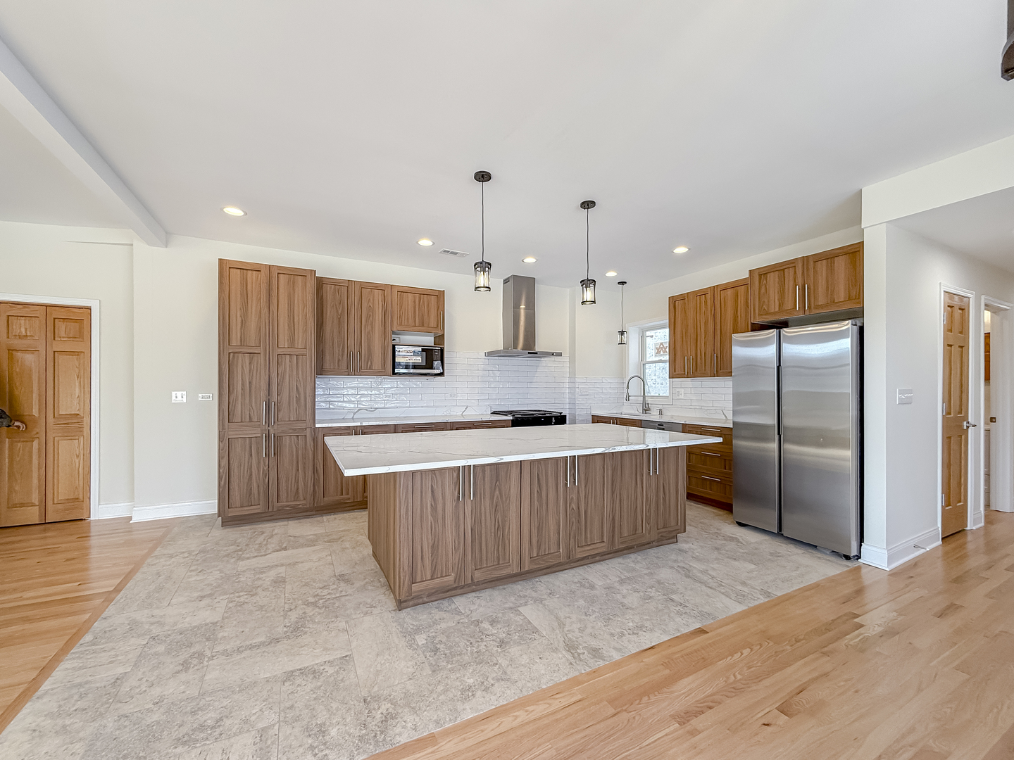 6411 West Irving Park Road, Unit 2 Chicago, IL 60634 - Photo 6 of 21 a large kitchen with a large counter top a refrigerator and a sink