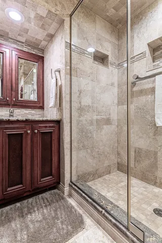 a bathroom with a granite countertop sink a mirror and shower