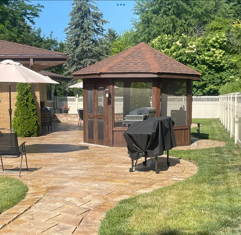 a view of a chair and table in the backyard of the house