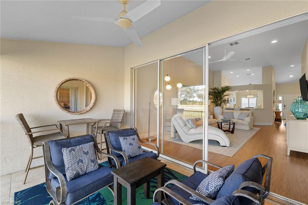 2215 Chesterbrook Court, Unit 2 Naples, FL 34109 - Photo 14 of 38 a living room with furniture a wooden floor and a chandelier