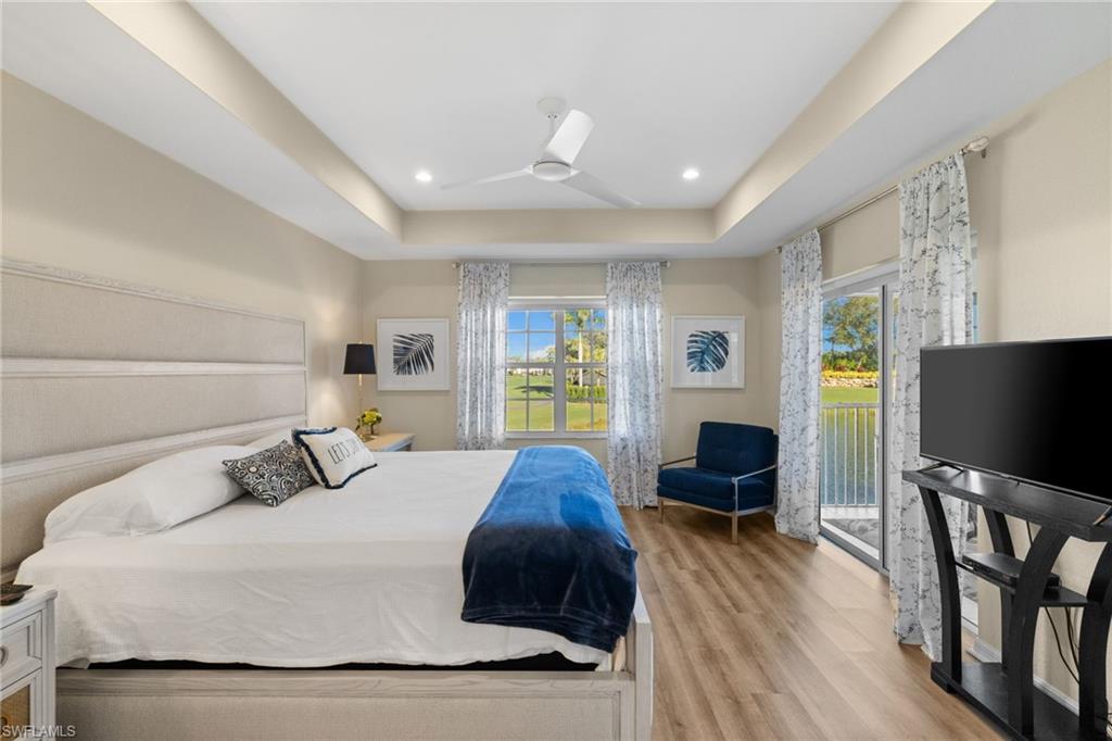 2215 Chesterbrook Court, Unit 2 Naples, FL 34109 - Photo 16 of 38 a bedroom with a bed window tv and wooden floor