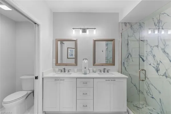 a bathroom with a double vanity sink mirror and toilet