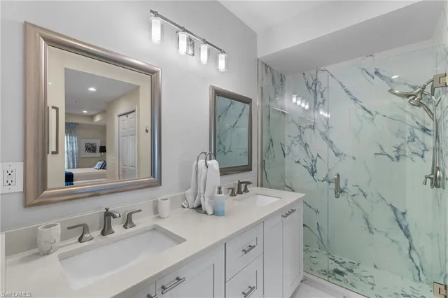 a bathroom with a double vanity sink mirror and shower