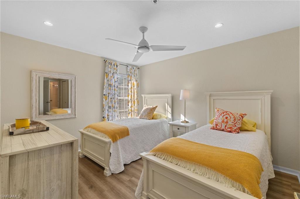 2215 Chesterbrook Court, Unit 2 Naples, FL 34109 - Photo 22 of 38 a bedroom with two beds and a chandelier