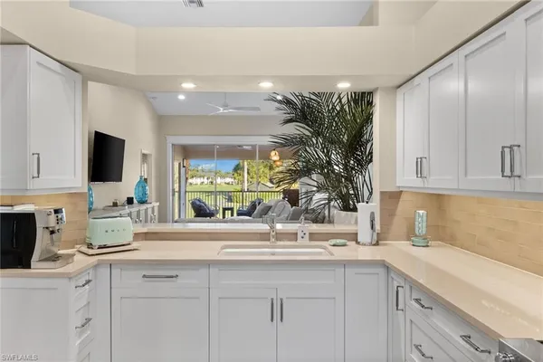 a kitchen with granite countertop a sink and white cabinets