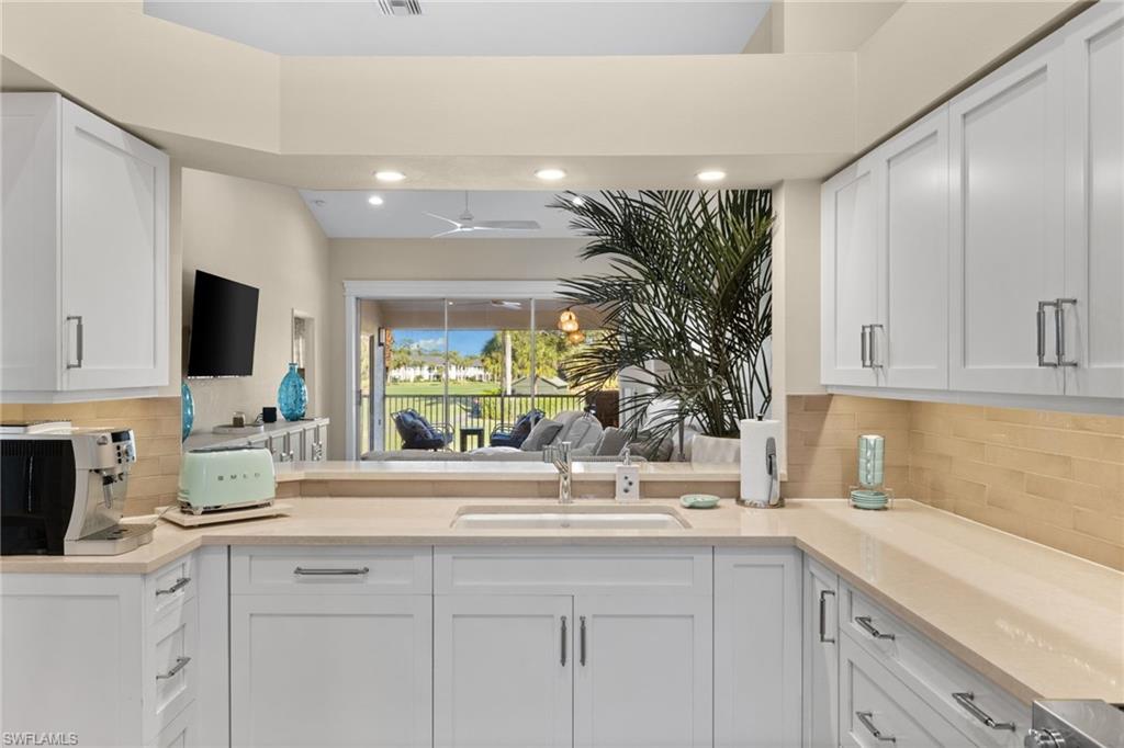 2215 Chesterbrook Court, Unit 2 Naples, FL 34109 - Photo 10 of 38 a kitchen with granite countertop a sink and white cabinets