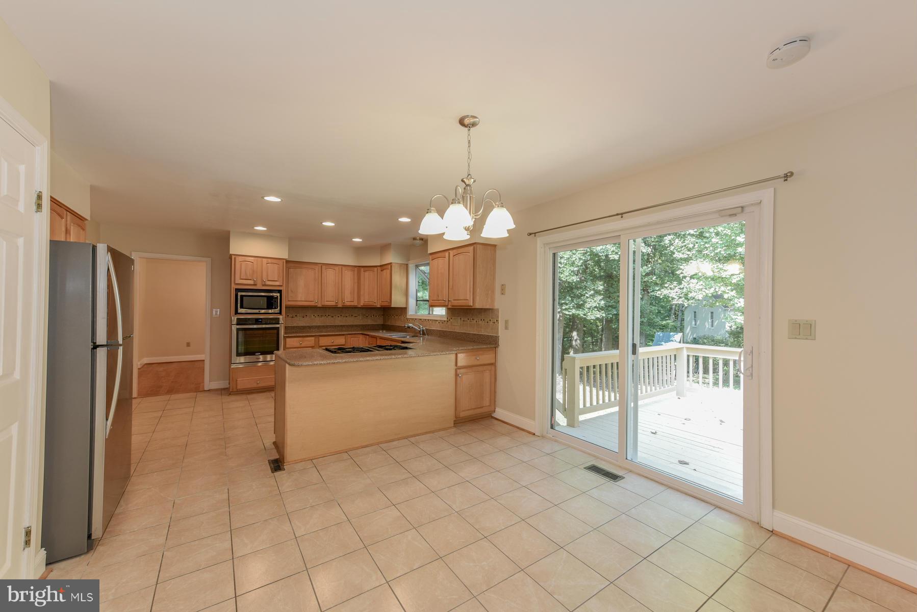 10541 Patuxent Ridge Way Laurel, MD 20723 - Photo 11 of 28 a kitchen with kitchen island granite countertop a refrigerator and a sink