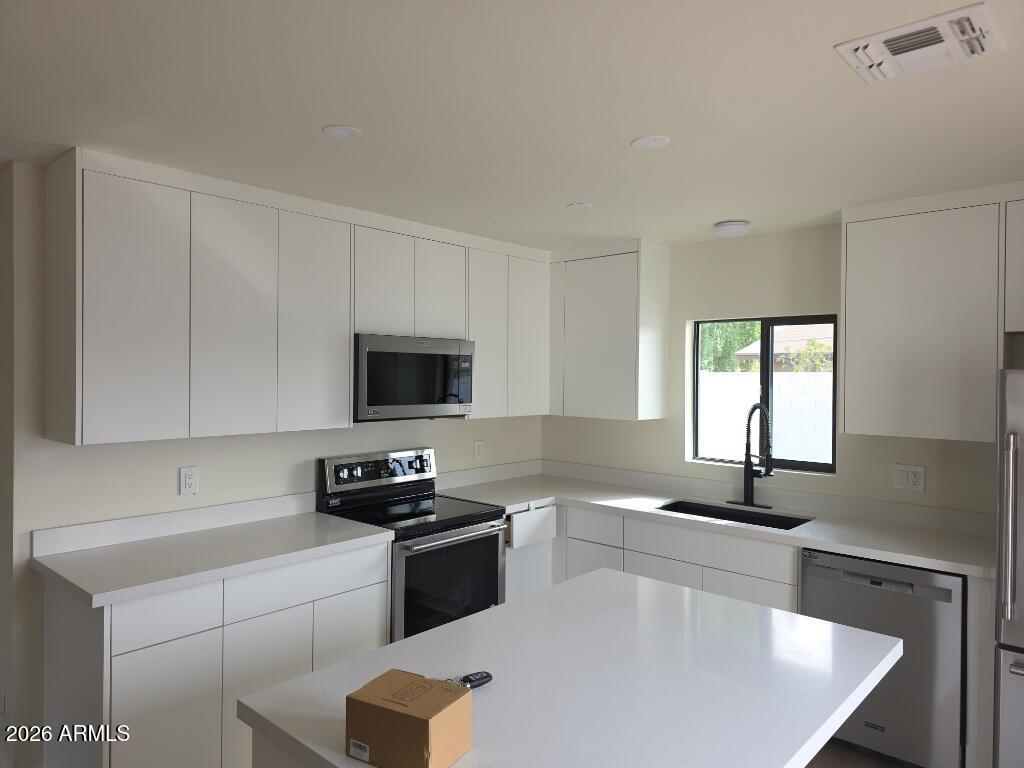 8015 West Roma Avenue Phoenix, AZ 85033 - Photo 6 of 15 a kitchen with a sink a stove and a microwave