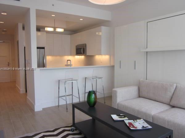 200 23rd Street, Unit 203 Miami Beach, FL 33139 - Photo 13 of 79 a living room with furniture and potted plant