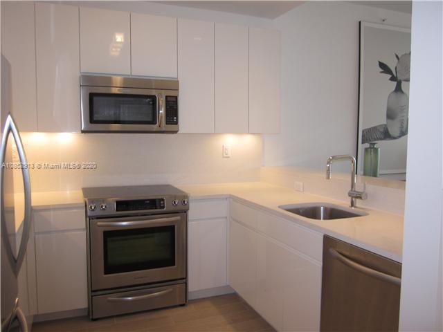 200 23rd Street, Unit 203 Miami Beach, FL 33139 - Photo 14 of 79 a kitchen with a sink and a microwave