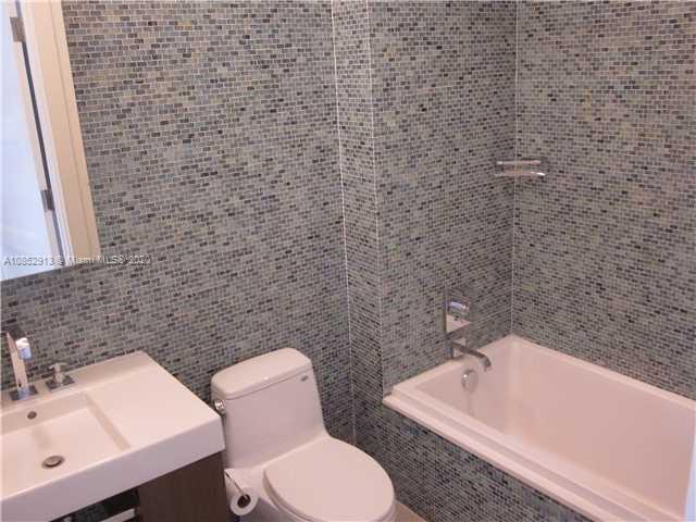 200 23rd Street, Unit 203 Miami Beach, FL 33139 - Photo 24 of 79 a bathroom with a toilet sink and mirror