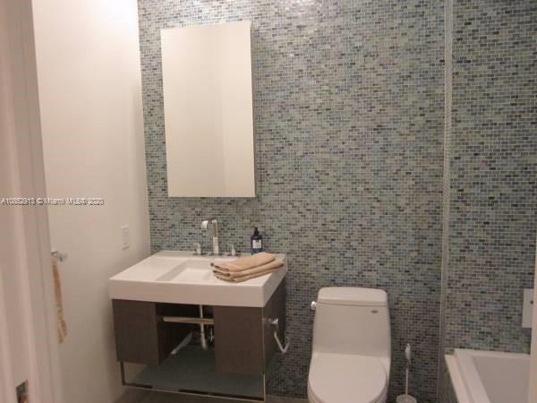 200 23rd Street, Unit 203 Miami Beach, FL 33139 - Photo 27 of 79 a bathroom with a toilet a sink and mirror
