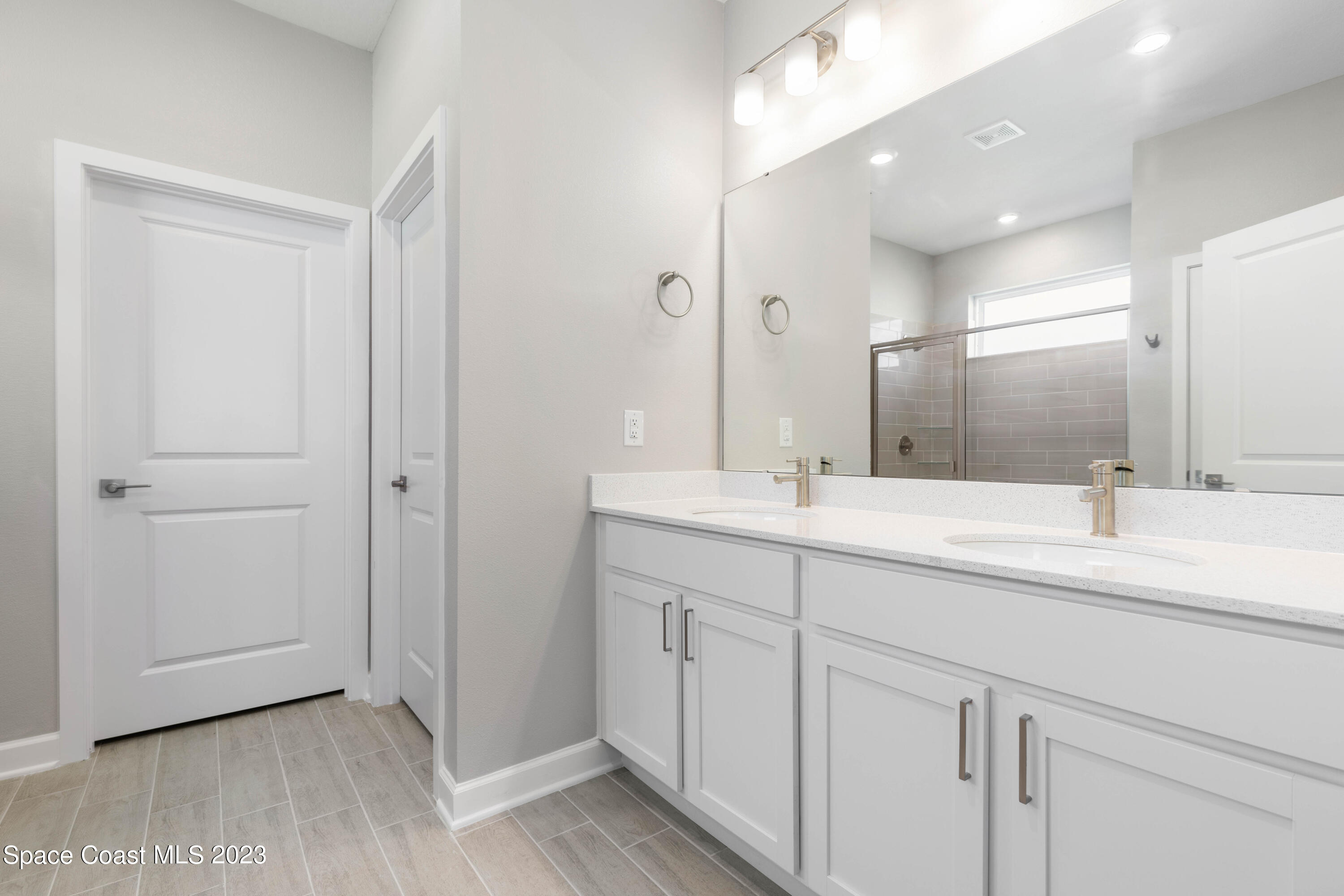 875 Clifton Road Southeast Palm Bay, FL 32909 - Photo 11 of 19 a bathroom with a double vanity sink and a mirror