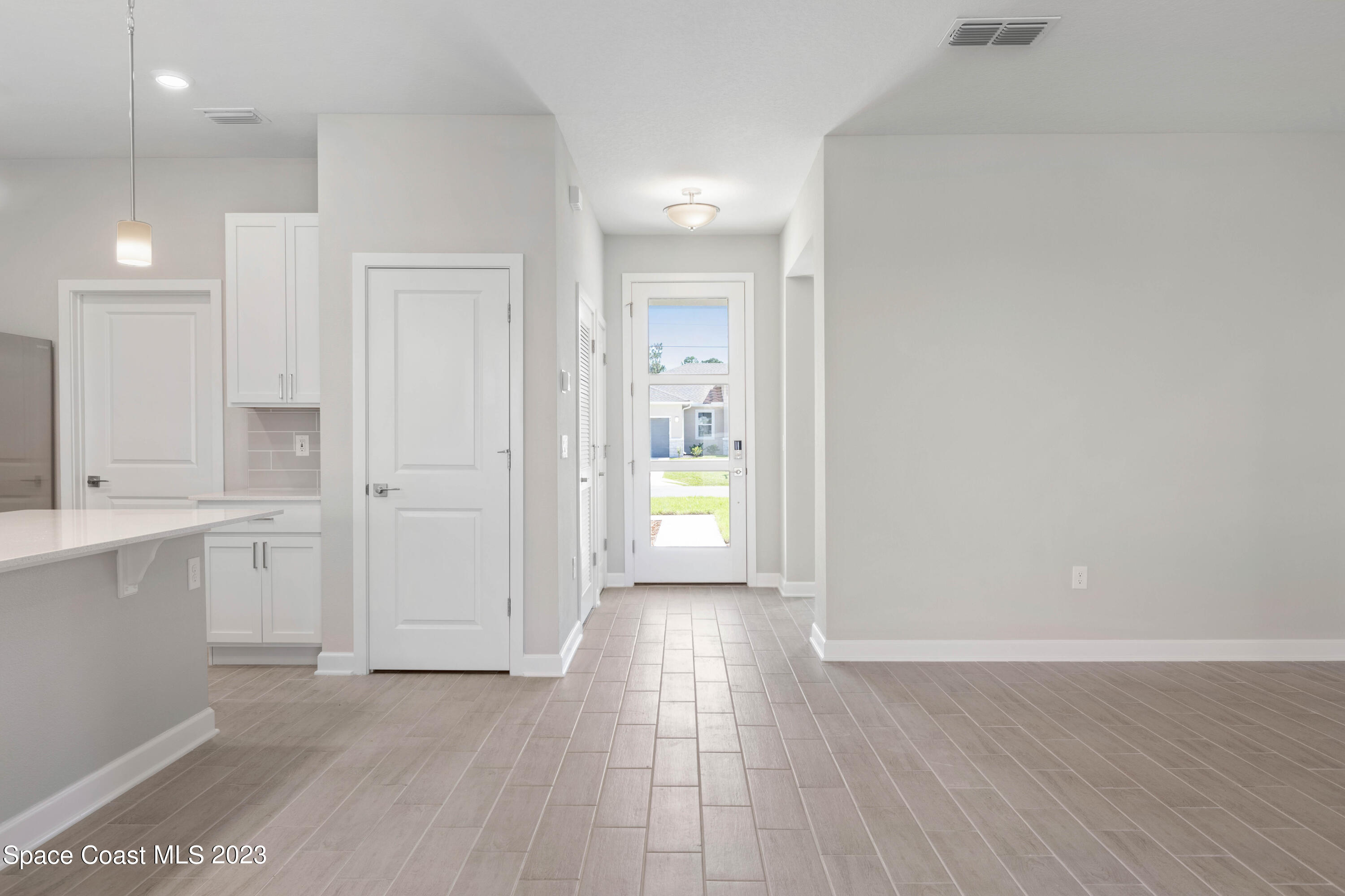 875 Clifton Road Southeast Palm Bay, FL 32909 - Photo 14 of 19 a view of an empty room with wooden floor and a window