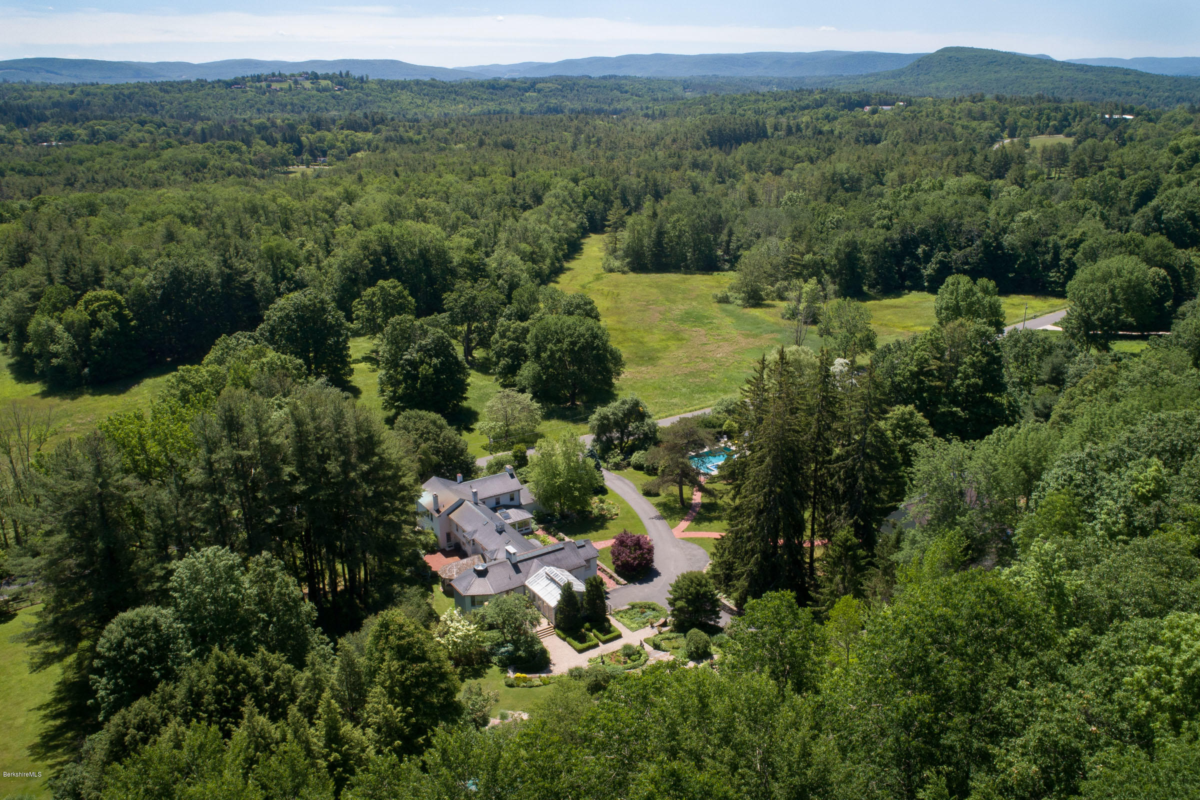 119 Under Mountain Road Lenox, MA 01240 - Photo 37 of 46 an aerial view of green landscape with trees houses and mountain view