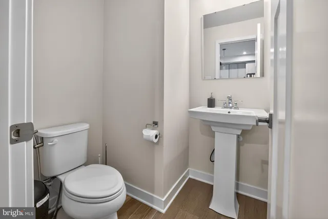 a bathroom with sink toilet and mirror