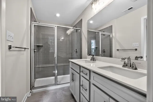 a bathroom with a shower sink vanity and mirror