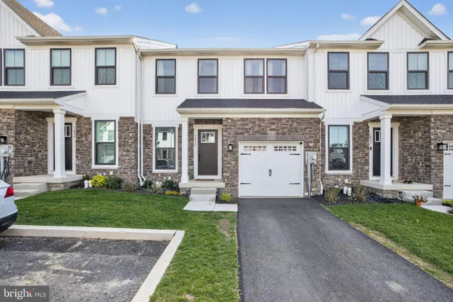 a view of a house with a yard and large tree