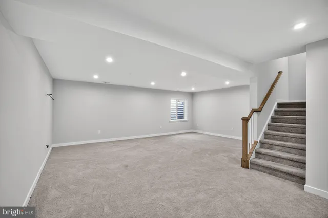 an empty room with stairs and wooden floor