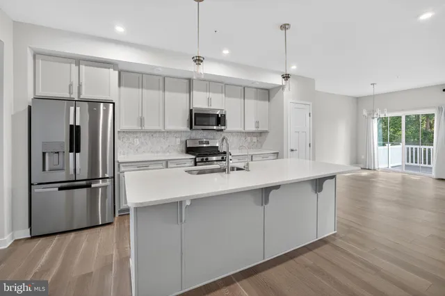 a kitchen with kitchen island a sink stainless steel appliances and cabinets