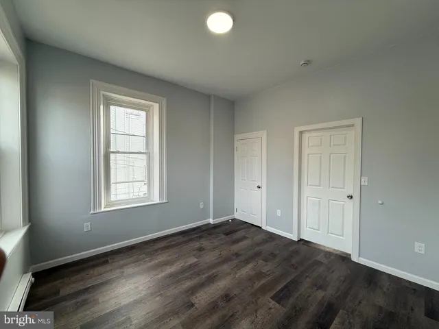 an empty room with windows and closet