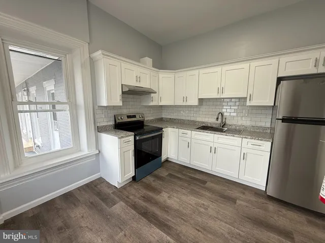 a kitchen with granite countertop white cabinets and white appliances