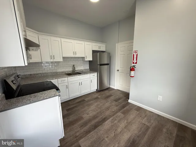 a kitchen with a sink a refrigerator and cabinets