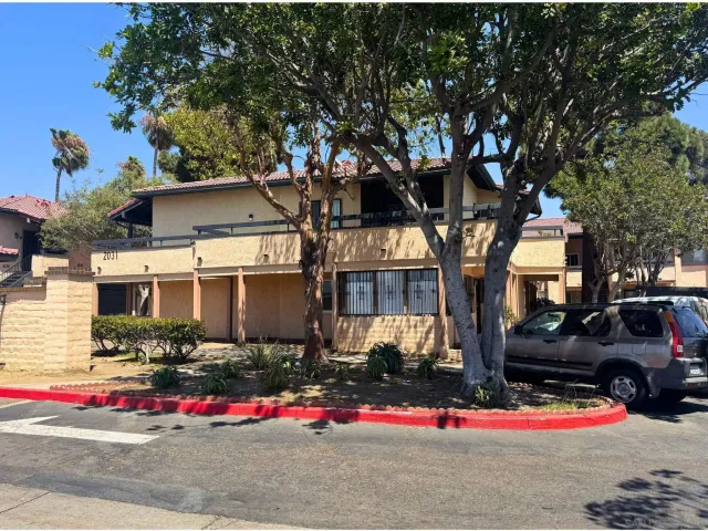 a front view of a house with a tree