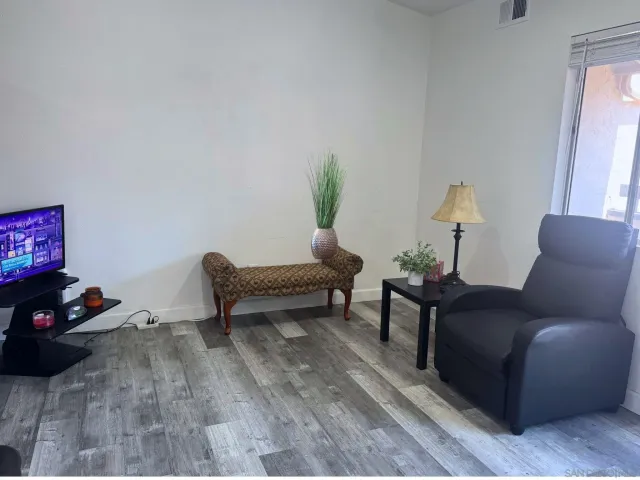 a living room with furniture and a wooden floor