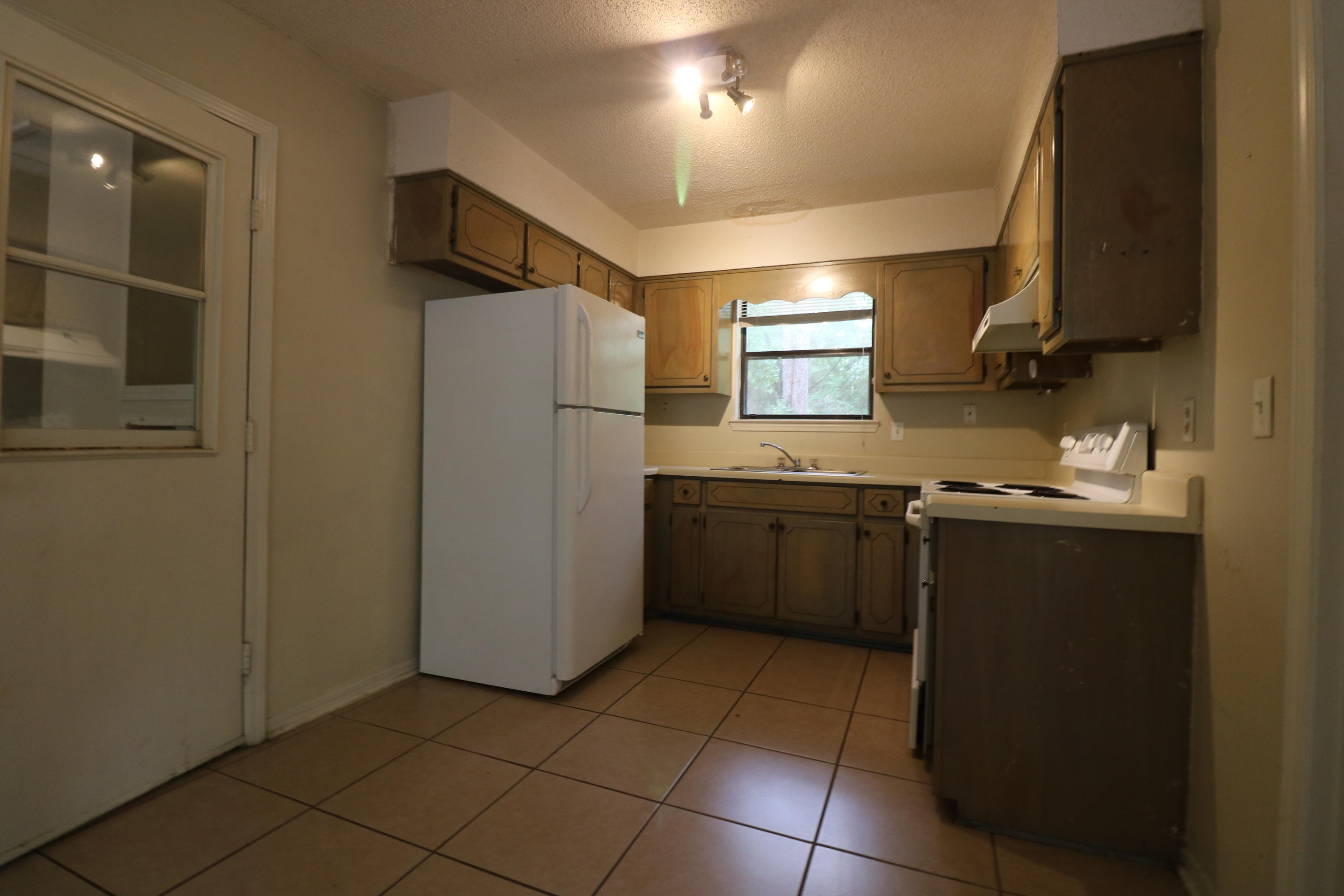 423 John King Road Crestview, FL 32539 - Photo 6 of 11 a kitchen with a sink a refrigerator and cabinets
