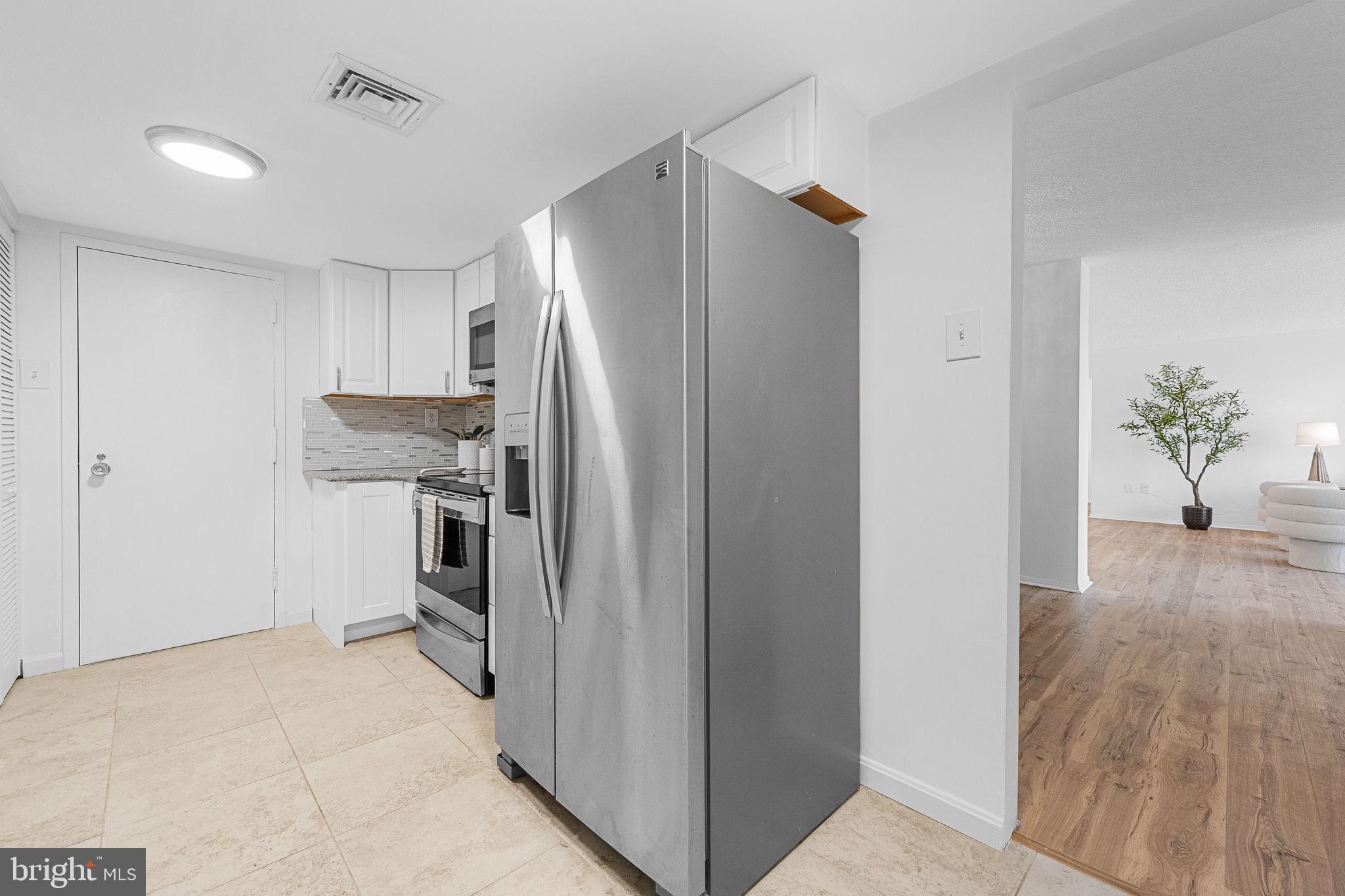 1515 South Arlington Ridge Road, Unit 703 Arlington, VA 22202 - Photo 20 of 44 a kitchen with stainless steel appliances a refrigerator and a hard wood floor