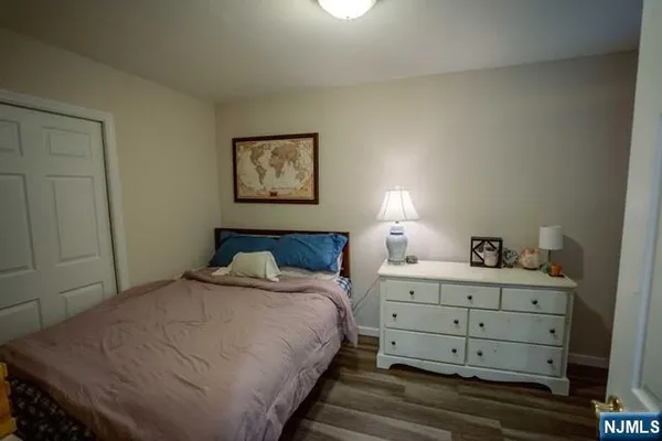 a bedroom with a bed and a lamp on dresser