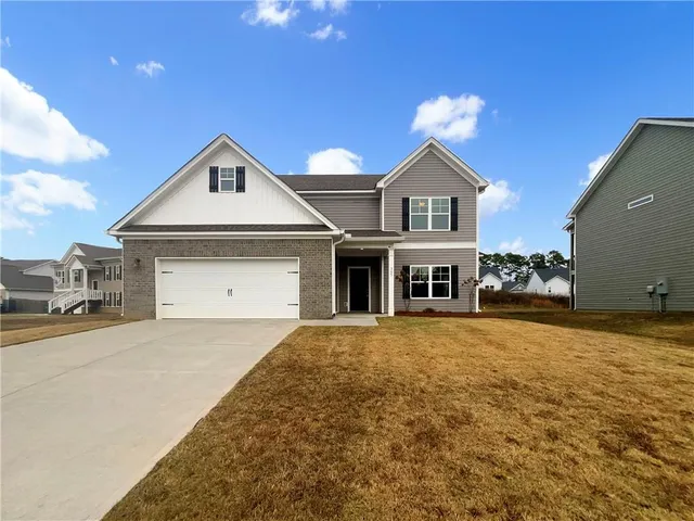 a front view of a house with a yard and garage