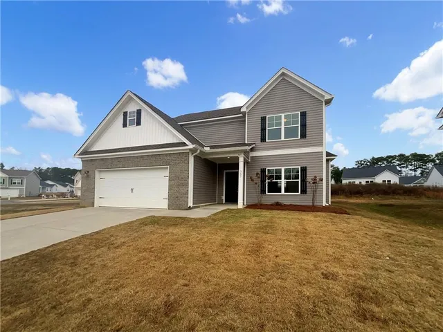 a front view of a house with a yard and garage