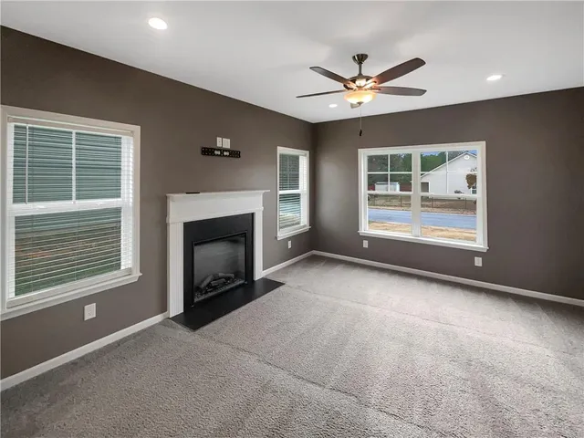 a view of an empty room with a fireplace and a window