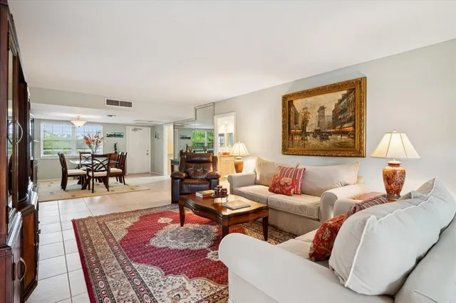 a living room with furniture a rug and a large window