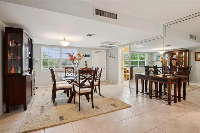 a dining room with furniture and a floor to ceiling window