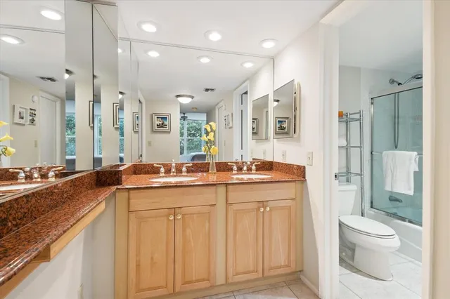 a spacious bathroom with a granite countertop sink mirror and toilet