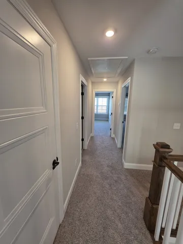 an empty room with windows and chandelier fan
