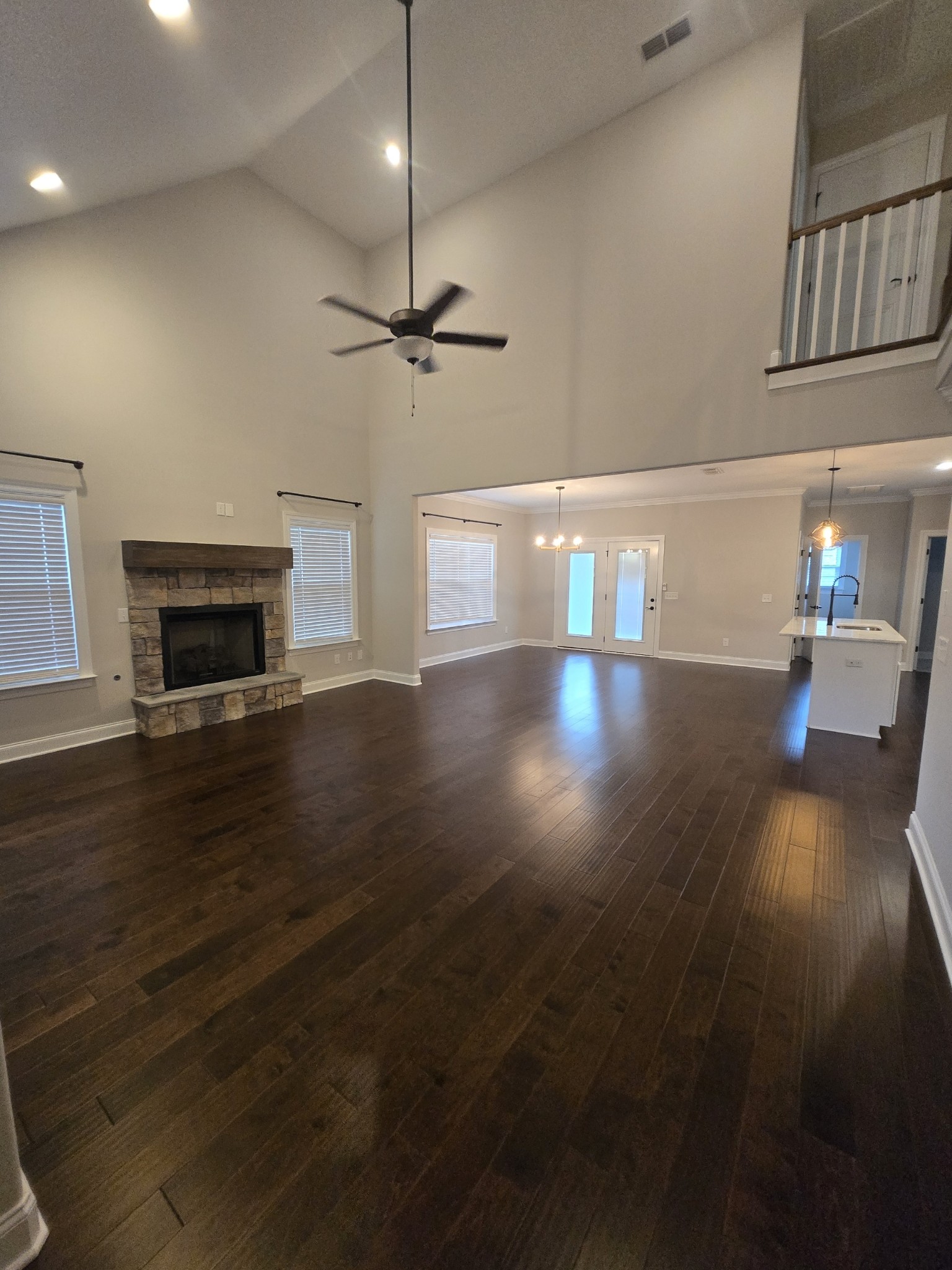 453 Ruby Oaks Lane Murfreesboro, TN 37128 - Photo 3 of 34 a view of a livingroom with wooden floor a ceiling fan and kitchen view